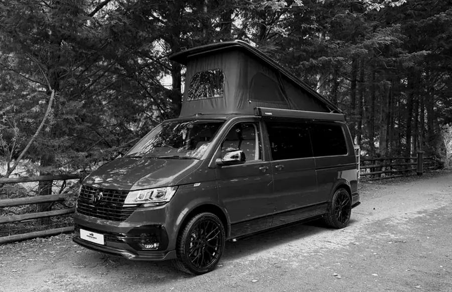 A campervan conversion parked on a woodland lane